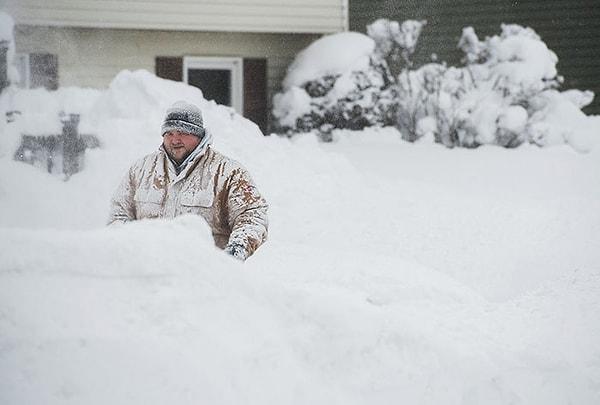 23. Erie, Pensilvanya'da rekor kıran kar yağışından sonra evinin önünü temizlemeye çalışan bir Erie sakini.