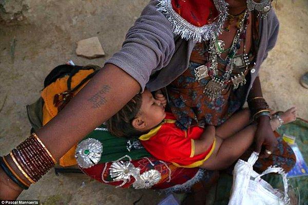 15. Jaisalmer, Hindistan sokaklarında bir çocuk annesinin kucağında uyuyor.