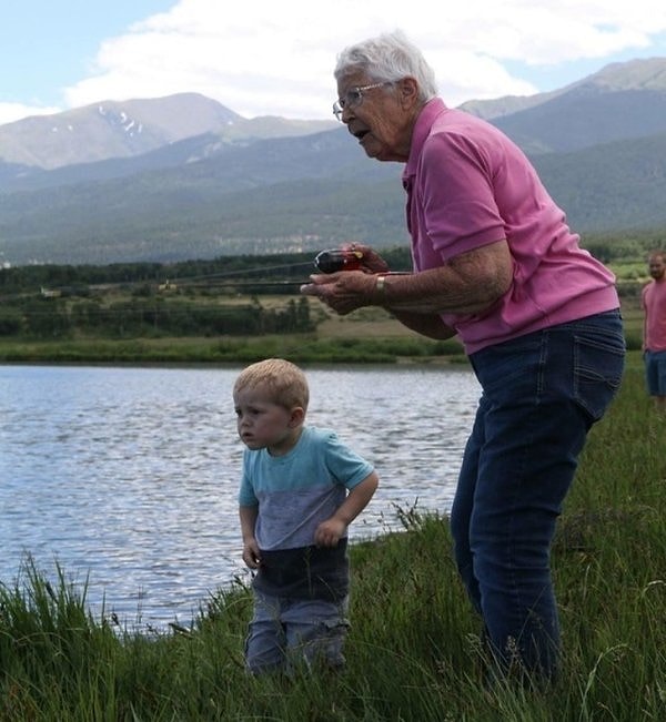 4. 89-летняя бабушка и 3-летний внук держат свою первую рыбу, которую они поймали вместе.