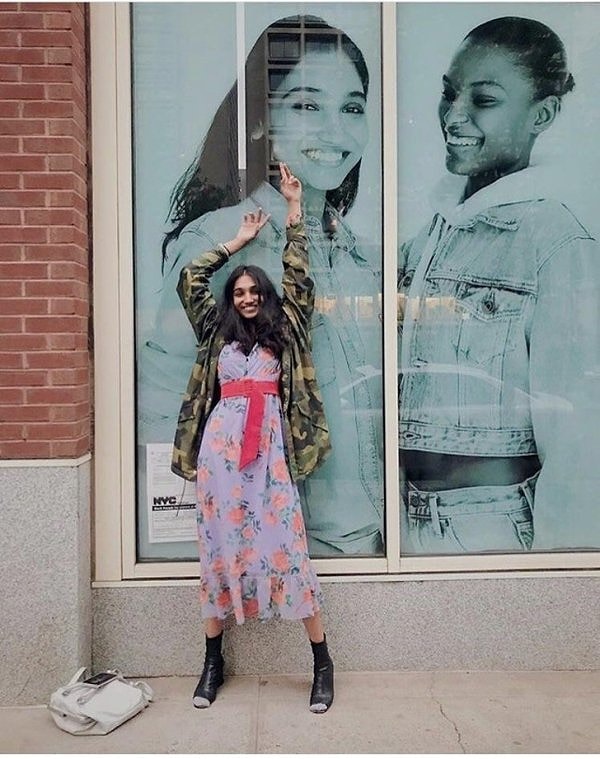 17. Улыбающаяся модель на фоне своего первого плаката на Бродвее.