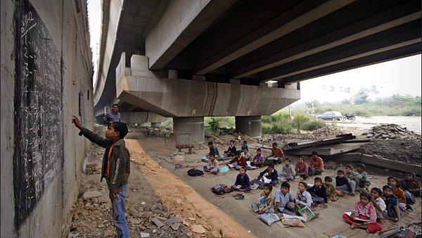 3. Rajesh Kumar Sharma adındaki bir öğretmen, New Delhi'deki fakir çocuklar için bir köprünün altında ders anlatıyor.