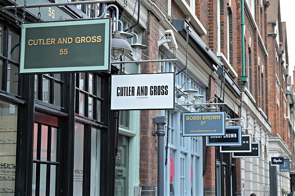 На отдельных вывесках в разной цветовой гамме и отличными шрифтами указаны названия магазинов и компаний, а также номера их зданий.