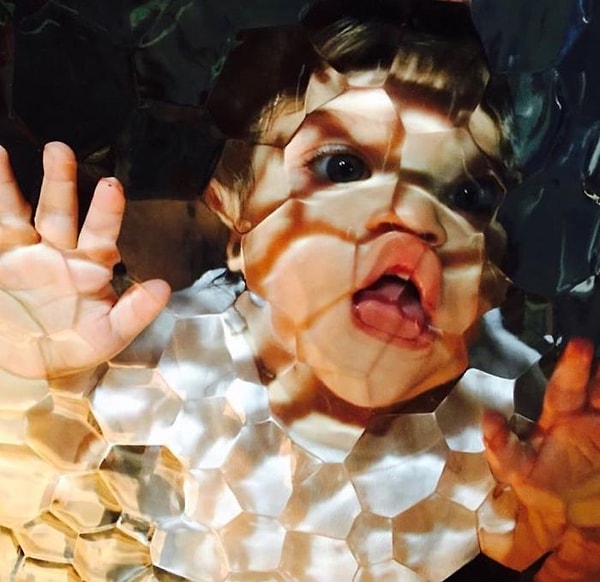 4. Малыш смотрит сквозь стекло двери, ведущей в ванную.