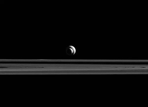 14. Satürn'ün halkalarının ardından görüntülenen Enceladus ve Tetys.