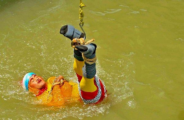 1. Thesun'dan derlediğimiz habere göre, demir zincir ve halatlarla bağlanarak Ganj Nehri'ne ayakları yukarıdan bağlı bir şekilde sokulan 40 yaşındaki Hindistanlı tehlikeli sahne dublörü, geçtiğimiz günlerde ölü bulundu.