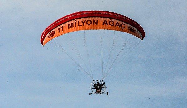 Malatya'da gökyüzünde bir motorlu paraşüt, '11 Milyon Ağaç' yazısı ile belirdi.