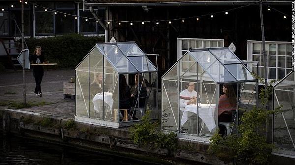 Hollanda'nın başkenti Amsterdam'da, sosyal mesafeyi koruma adına cam kabin uygulaması getiren restoran tüm dünyaya örnek oldu.