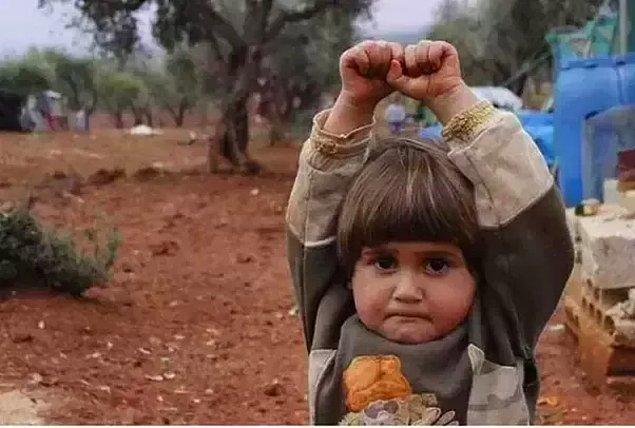2. Suriyeli çocuk, kamerayı silah sandığı için ellerini kaldırıyor.