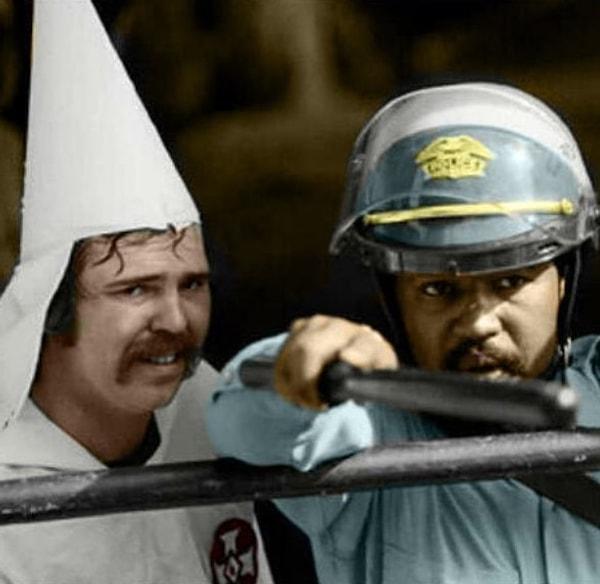 5. Siyahi bir polis, protestolar sırasında KKK üyesini koruyor.