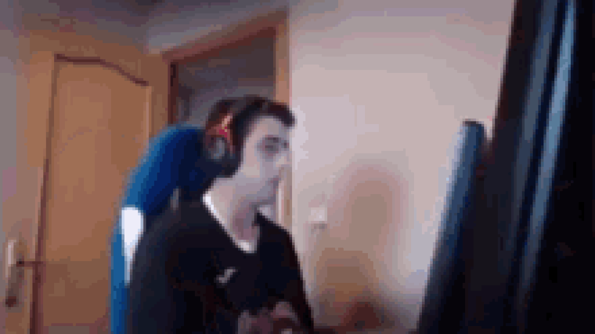A man banging his table with his fist so hard, that the keys from his keyboard fly upwards.
