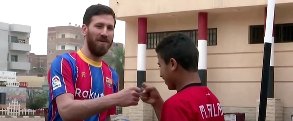 4. Художник с удовольствием позирует для фото в футболке Барселоны и гоняет в мяч, вызывая у детишек море радости.