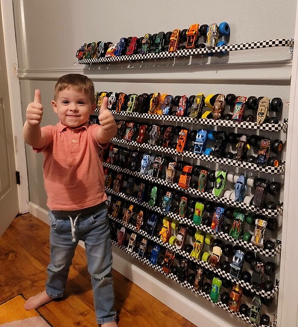 3. Я сделал настенную стойку для хранения / демонстрации грузовиков-монстров моего ребенка. Менее чем за 20 баксов я использовал карнизы и клейкую ленту с клетчатым флагом