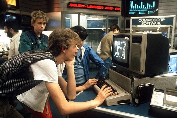 4. Almanya Nuremberg'de bir grup genç teknoloji mağazasında Commodore bilgisayar ile oynuyor. -1984