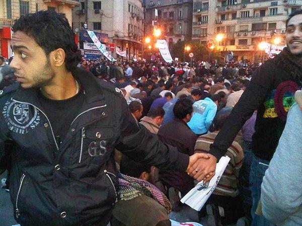 9. Ocak 2011'de Kahire ayaklanması sırasında Hristiyanlar ve Müslümanlar dayanışma içinde el ele tutuşuyorlar.