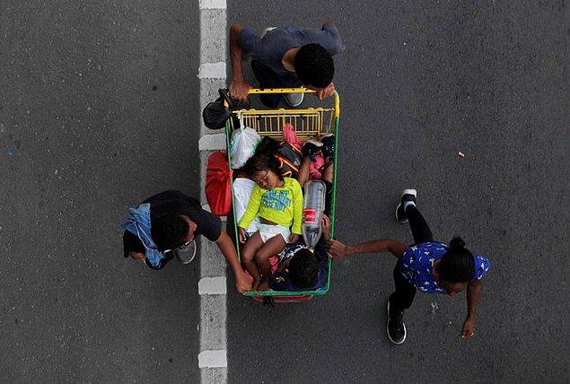 47. Daniel Becerril perspektifinden Meksika'da göçmen bir aile, çocuklarını bir alışveriş arabasında taşıyor.