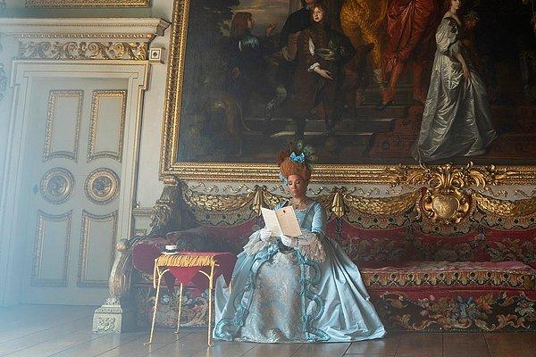 Üçüncü resimde, Kraliçe Charlotte'ın, bir broşür okuduğunu görüyoruz.