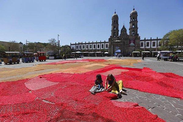 7. "Aktivistler, Meksika'nın Zapopan kentinde kadın cinayetlerine dikkat çekmek için kırmızı kumaştan yapılmış 'Kanımın Kanı' başlıklı bir sanat eseri inşaa ettiler."