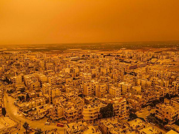 Suriye'nin İdlib kentinde etkili olan kum fırtınası şehrin üstüne sarı bir örtüyle kapladı. 📸