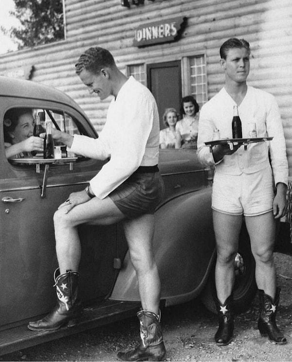23. 1940'larda, Teksas, Dallas'ta bir araba yolunda kadınlara şort ve kovboy çizmeleri giyinmiş erkekler hizmet verdiği "Log Lodge Tavern".