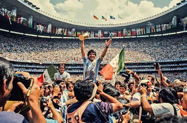 Diego Maradona'nın bir elinde Dünya Kupası'nı tuttuğu ve diğer elinde Katar bayrağını gösterdiği 1986 tarihli bu fotoğraf.