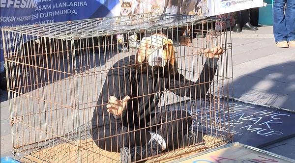 Konuşmaların ardından bir hayvansever, hayvanlara yönelik şiddete dikkat çekmek için köpek maskesi takarak bir süre kafeste bekledi.
