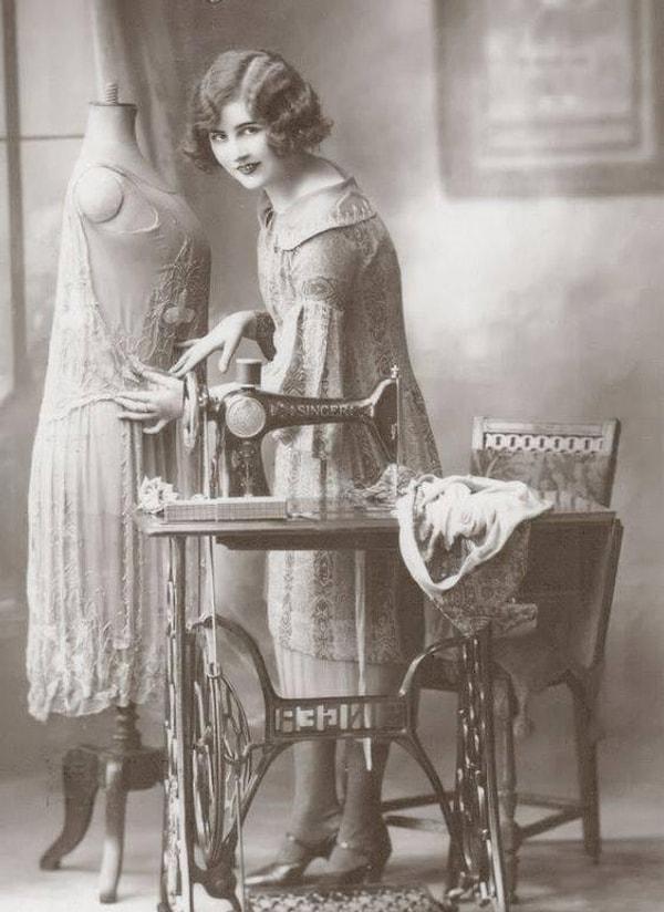 7. 1920'lerde dikiş makinesiyle diktiği güzel elbiseyi düzeltmeye çalışan genç bir kadın: