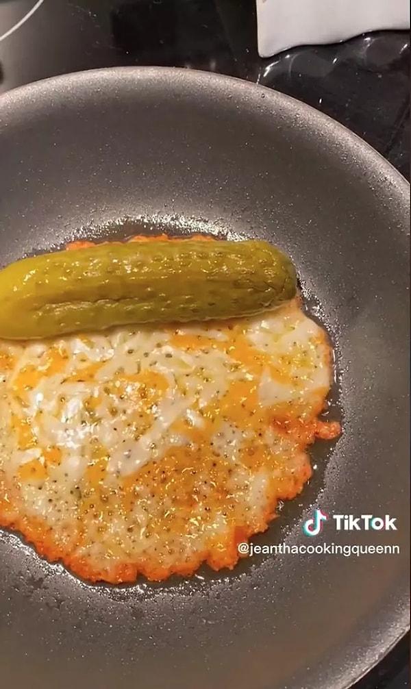 To make the recipe, you need to cut two slices of cheese finely and put them in a frying pan that is thoroughly heated. After waiting for the cheese to become crusty and golden, you can add a pickle over low heat and wrap the fried cheese around it