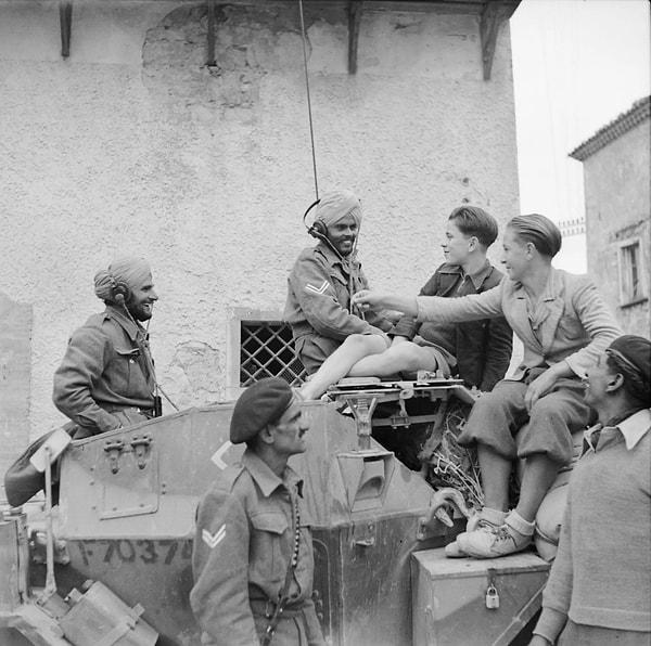 5. Tank üzerinde oturan Hindistanlı askerler, İtalya'da öğrencilerle muhabbet ediyor. (1943)
