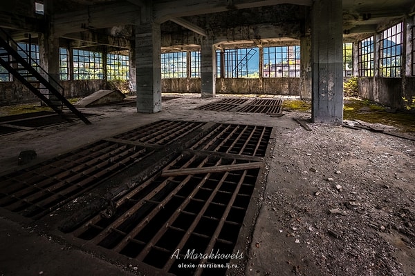 13. Внутри здания можно увидеть осколки разбитых окон, стены в граффити, и оборудование, покрытое ржавчиной.