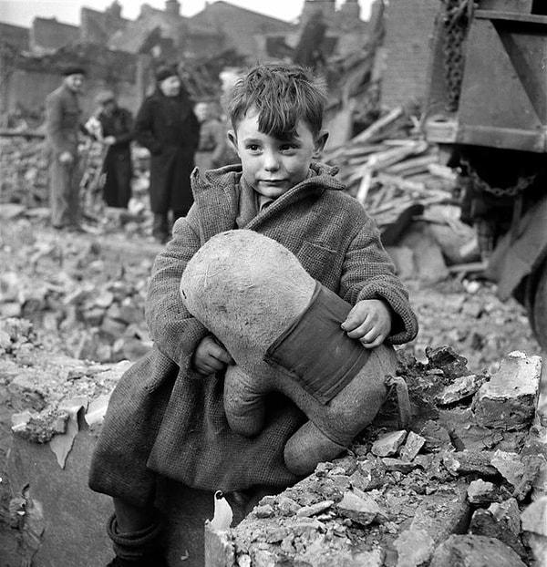 12. Bu fotoğraf 1945'te fotoğrafçı Toni Frissel tarafından çekildi. Tüm ailesi yıkılan binanın altında kalmış Londralı çocuk oyuncağı ile evinin yıkıntılarının yanında oturuyor.