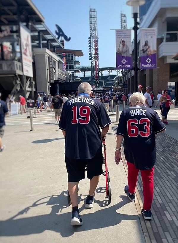 15. "1963'ten beri birlikteyiz." yazılı tişörtler giyen sevimli bir çift.