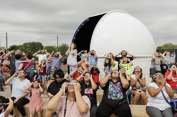 Binlerce kişi halkalı Güneş tutulmasını izlemek için  açık alanlarda toplandı ve koyu renkte ışık korumalı gözlükleri ve teleskoplarıyla saatlerce bekledi.