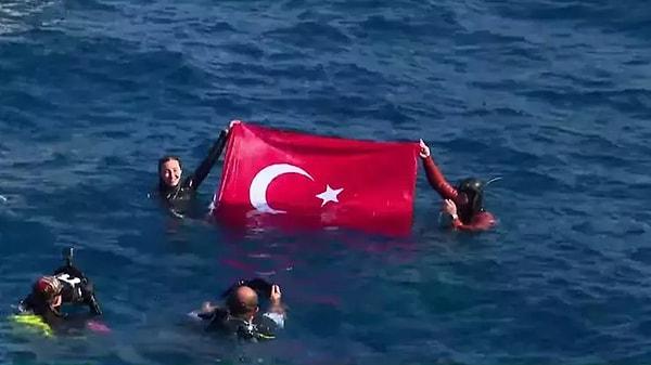 Hatay Yayladağı'ndaki dalışının ardından su üzerine çıkan Ercümen, dünya rekorunu Türk bayrağı açarak kutladı.