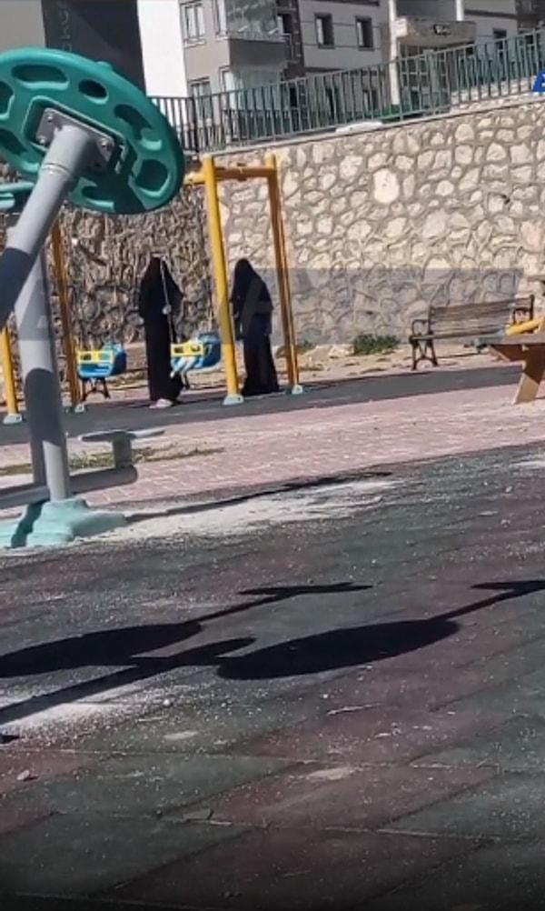 Mahallede bulunan çocuk parkına gelen iki kara çarşaflı kadın, ellerindeki oyuncak bebeği salıncakta sallarken görüntülendi.