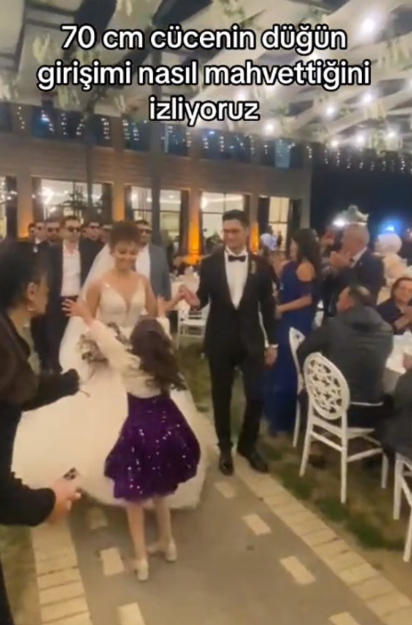 "70 cm cücenin düğün girişimi nasıl mahvettiğini izliyoruz" başlığıyla paylaşılan videoda bir kız çocuğunun gelini görünce ona sarılmaya gidişi yer alıyor.