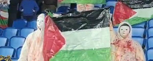 Protestocular, tribünde kendilerine ayrılan boşluğa geçerek Filistin bayrakları açtı.
