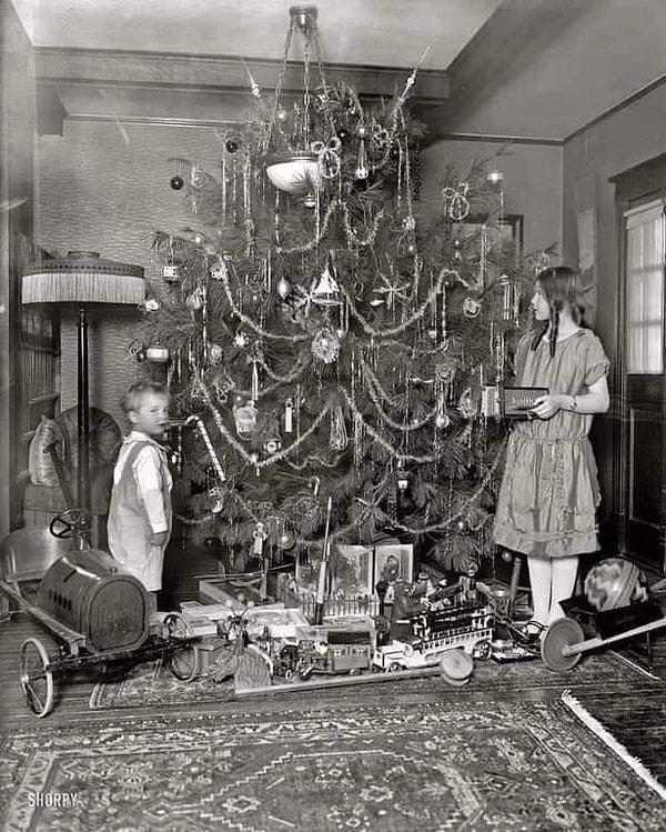 6. Noel ağacının etrafında duran iki çocuk. 103 yıl önce Noel nasıl görünüyordu gösteren bir fotoğraf. (1920)