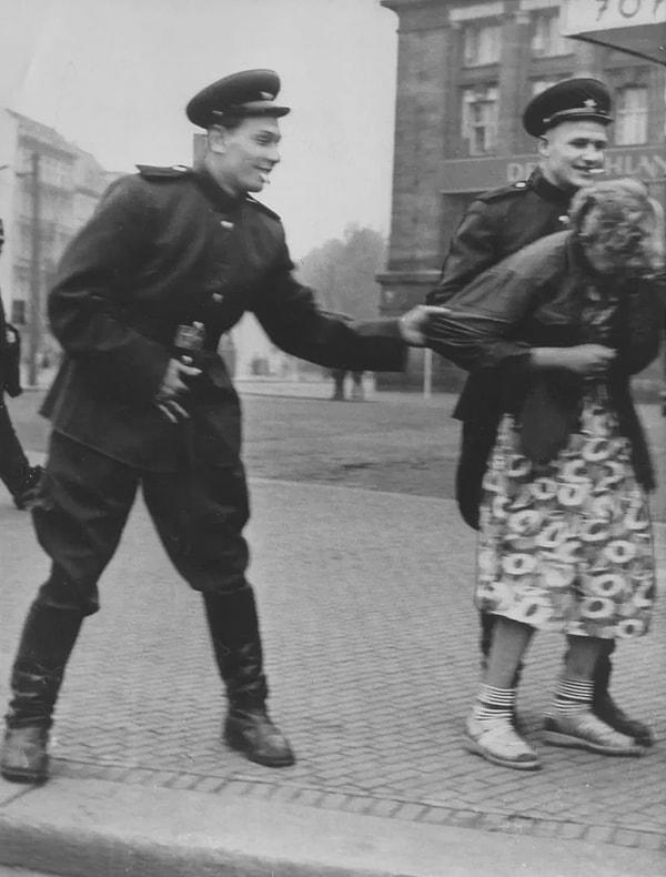 12. Sovyet askerleri 1945'te Almanya'nın Leipzig şehrinde bir kadını taciz ederken çekilmiş bir fotoğraf.
