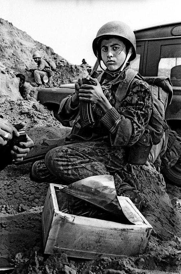 11. Genç bir İranlı asker Iraklı işgalcilere karşı savaşa hazırlanırken çekilmiş bir fotoğraf. (Khuzestan, Kasım 1981. Fotoğraf: Alfred Yaghobzadeh)