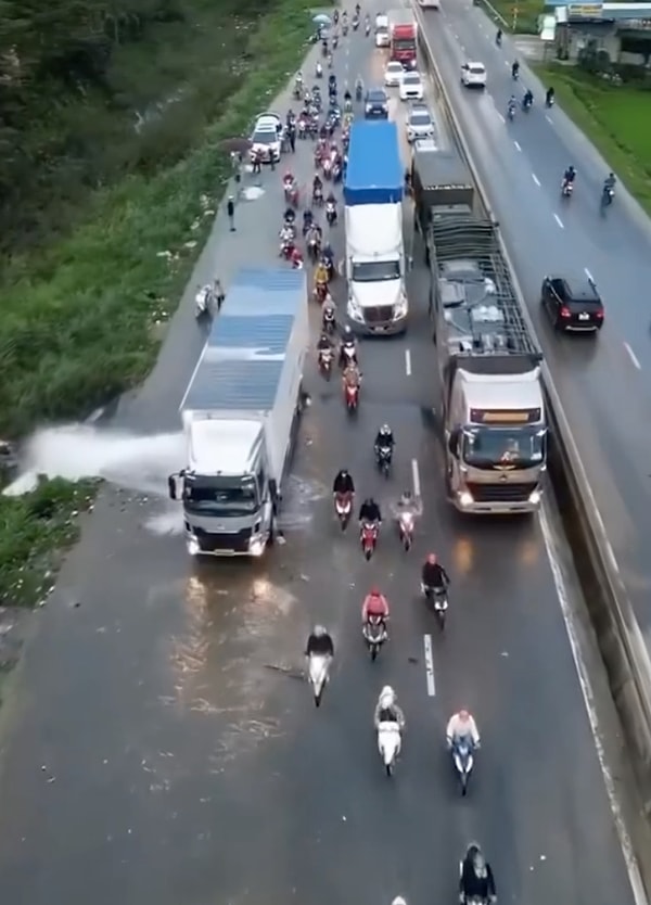 Patlayan su borusu yola doğru akarken, motor sürücüleri kenardan geçebilmek için çaba sarf etmekteydi.