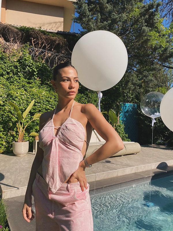 Demet Özdemir,sırt dekoltesiyle dikkat çeken bluzunu, aynı renk ve kumaşa sahip bol bir pantolonla birleştirerek şık bir kombin oluşturmuş. Bu canlı ve pembe renkteki kombin, onun enerjik ve canlı kişiliğini mükemmel bir şekilde yansıtıyor.