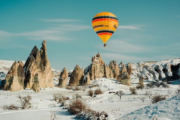 1. Hot Air Ballooning Over Snowy Valleys