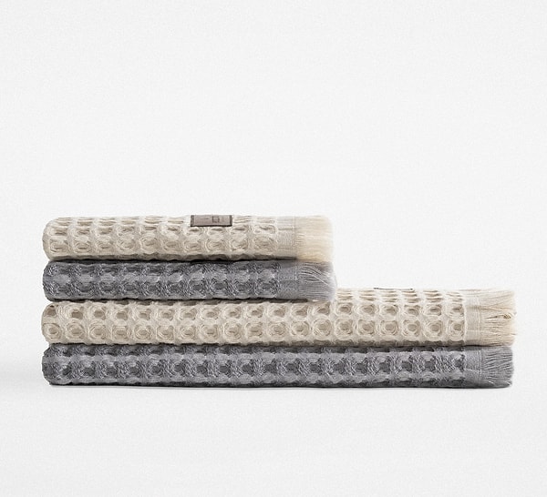 Seren 4’lü havlu seti, organik pamuk dokusuyla cilde yumuşak ve konforlu bir his verirken, bej–antrasit renk uyumuyla banyonuza modern bir hava katacak.