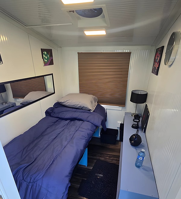 It includes a bed, storage space, and a heater.